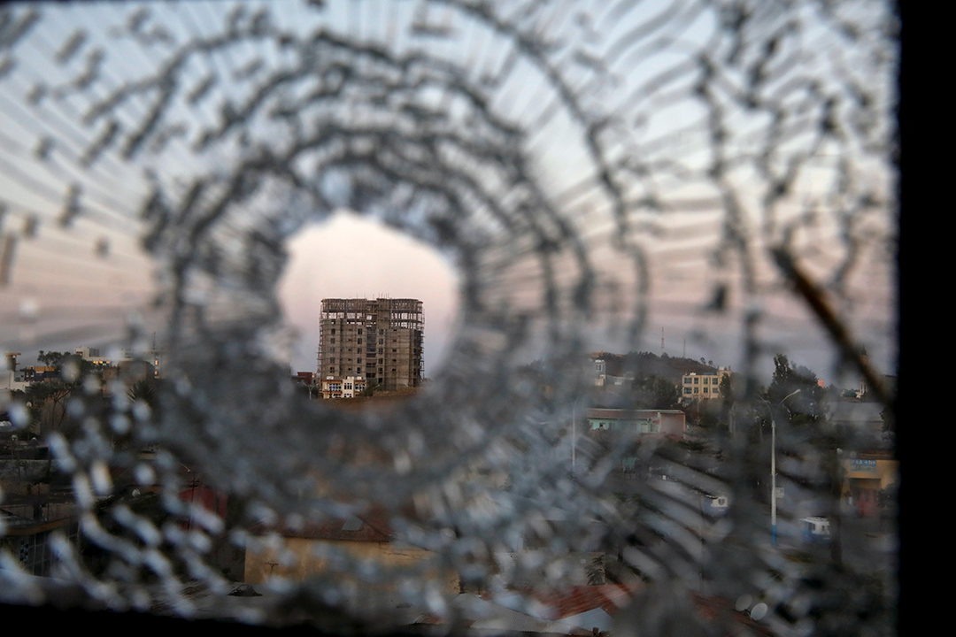 Shattered glass window looks out onto a tall building