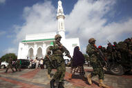 Soldiers serving in the African Union Mission in Somalia patrol outside a Mosque. 