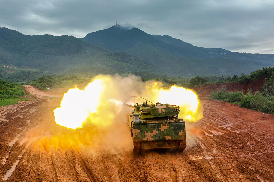 Tank shoots missile in front of mountain.
