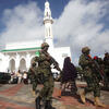 Soldiers serving in the African Union Mission in Somalia patrol outside a Mosque. 