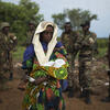 Woman holding baby escorted by African Union troops.