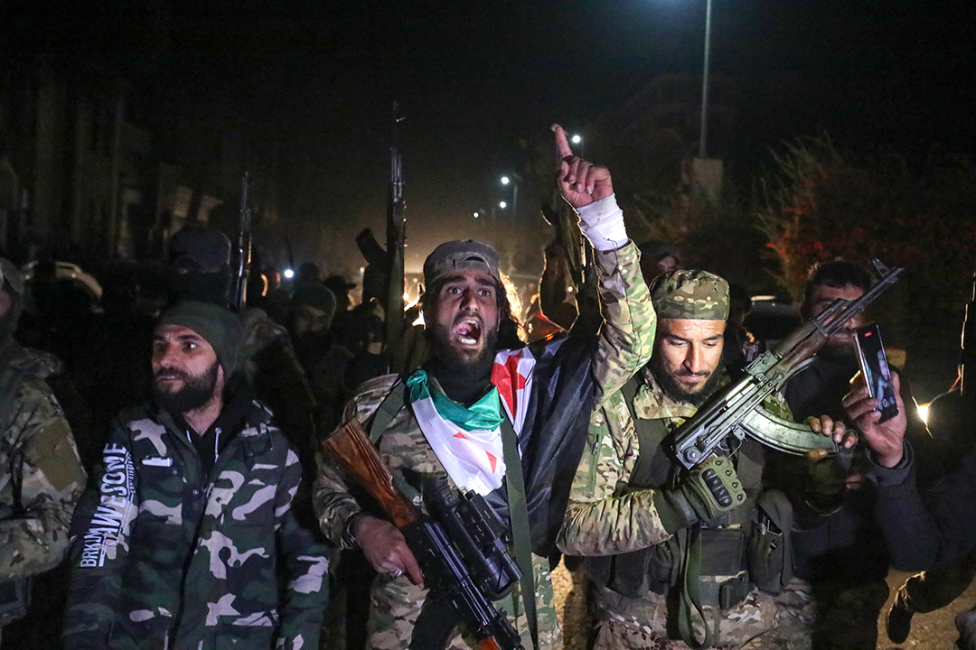 A soldier waves his fist in the air surrounded by people